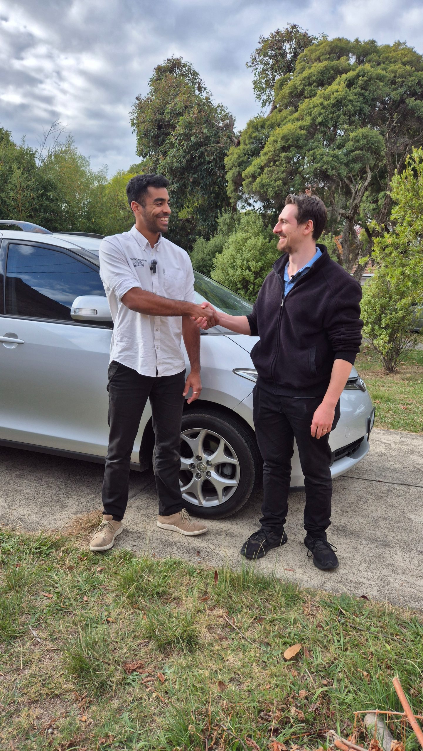Client with advisor beside a silver car