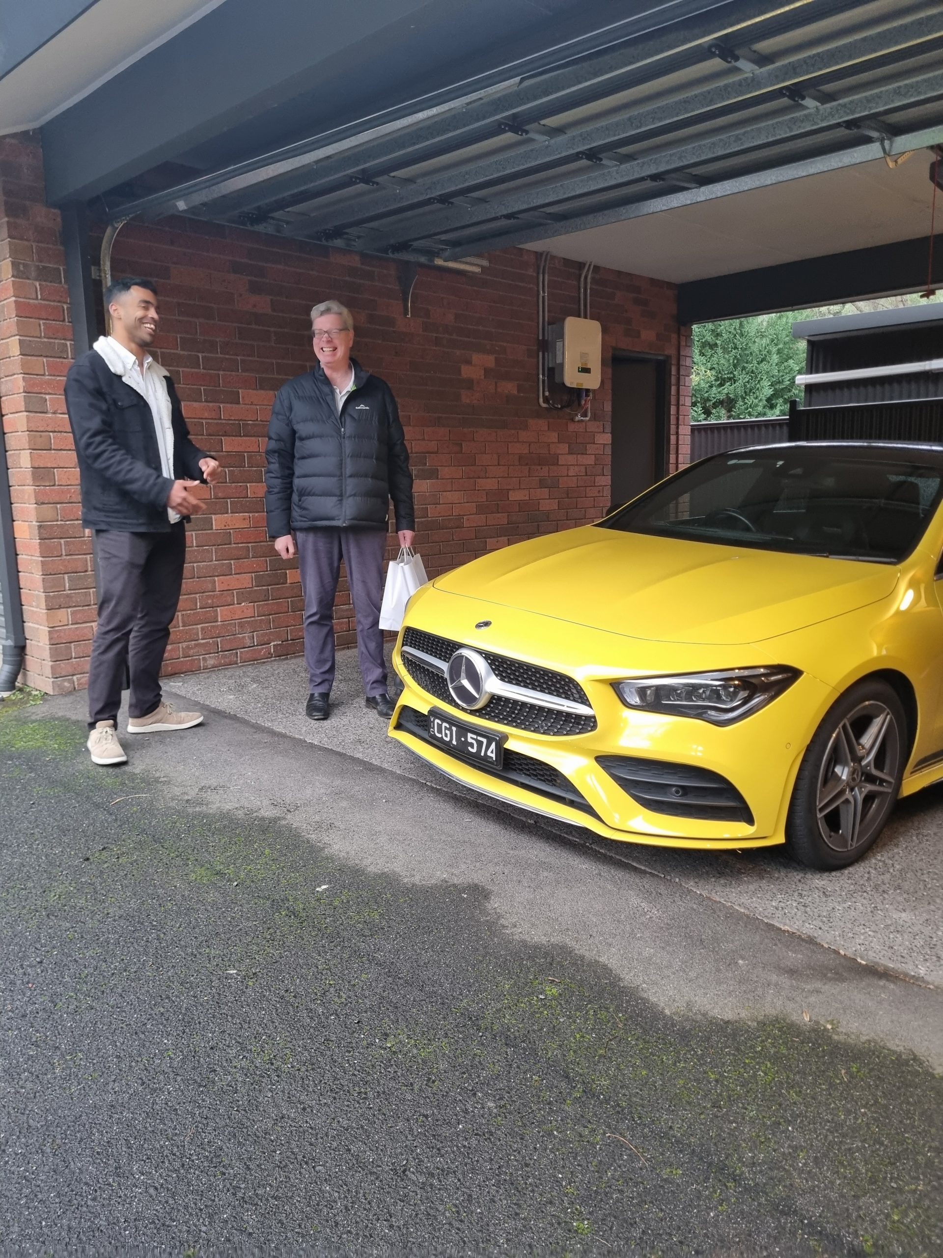 Advisor giving expert advice beside a yellow car